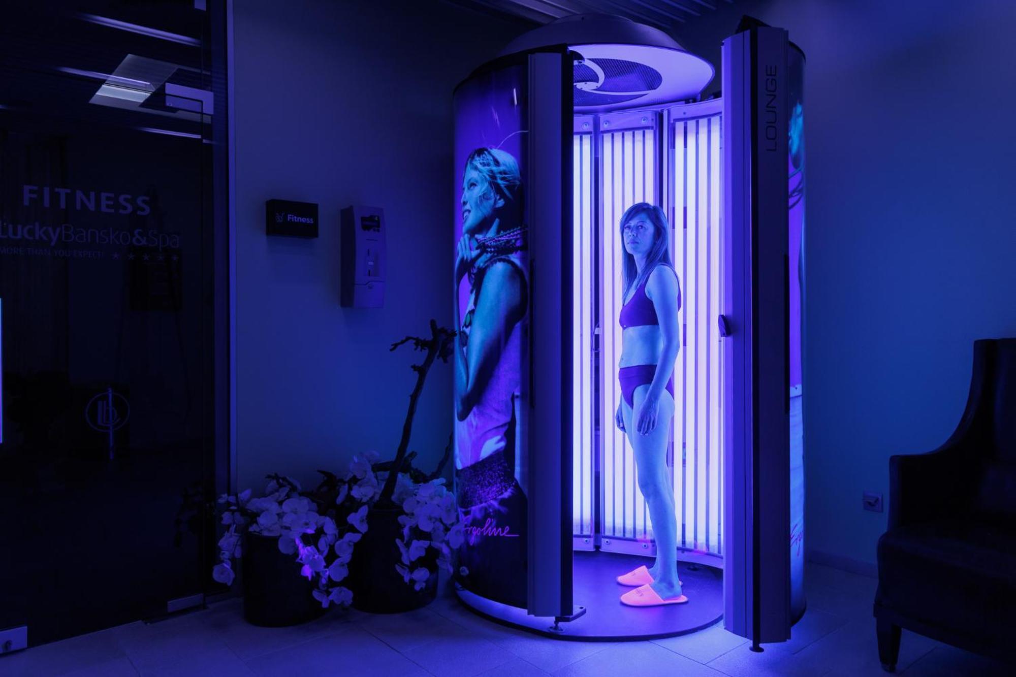 Lucky Bansko Aparthotel Spa & Relax Kültér fotó A woman tanning in a solarium